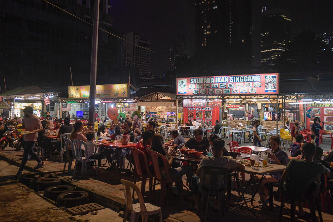 Customers dine in at a stall in Kuala Lumpur after the government extended the opening hours for restaurants and eateries to midnight. Photo: Bernama