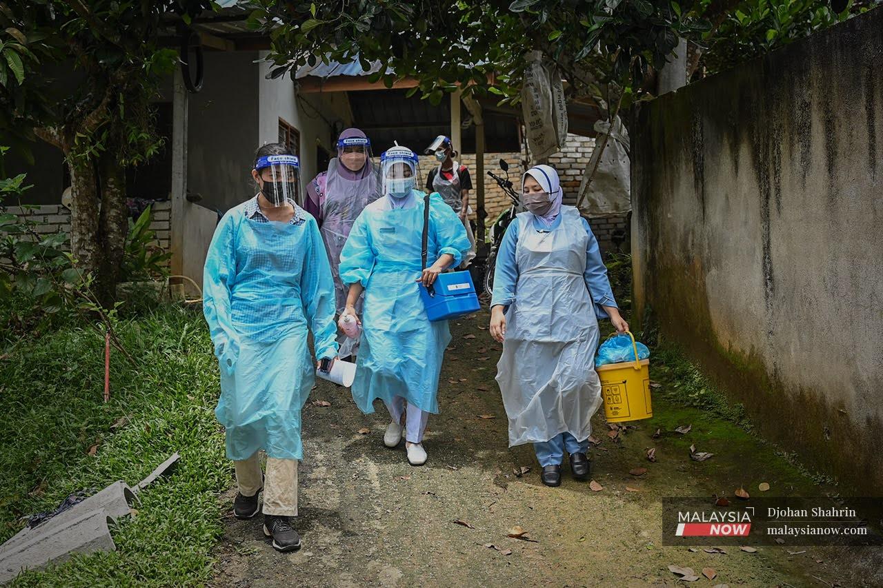 Beberapa petugas kesihatan dari Pejabat Kesihatan Hulu Selangor berjalan menuju ke beberapa buah rumah Orang Asli Temuan di  Kampung Orang Asli Buluh Telur, Kuala Kubu Bharu untuk menjalankan vaksinasi.