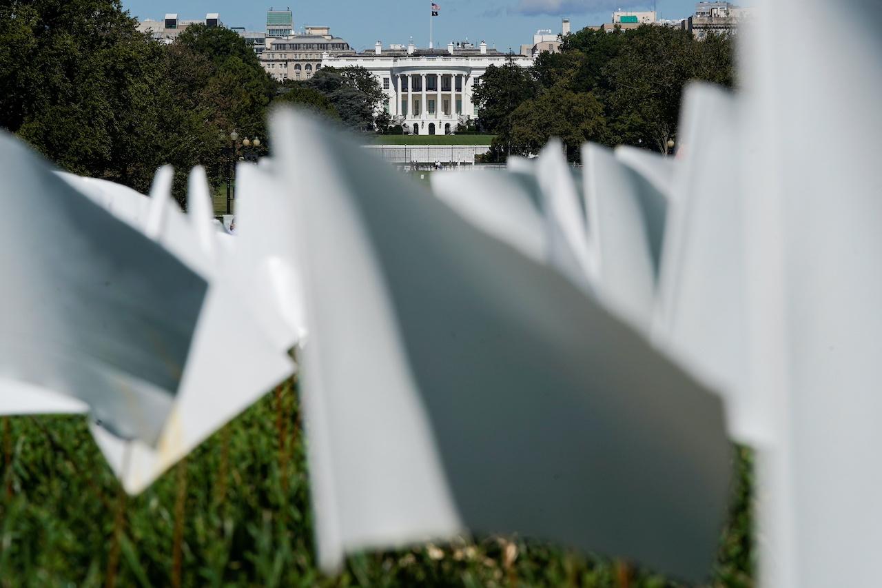 The White House is seen through thousands of white flags representing Americans who have died of Covid-19, placed over 20 acres of the National Mall in Washington, Sept 26. Photo: Reuters