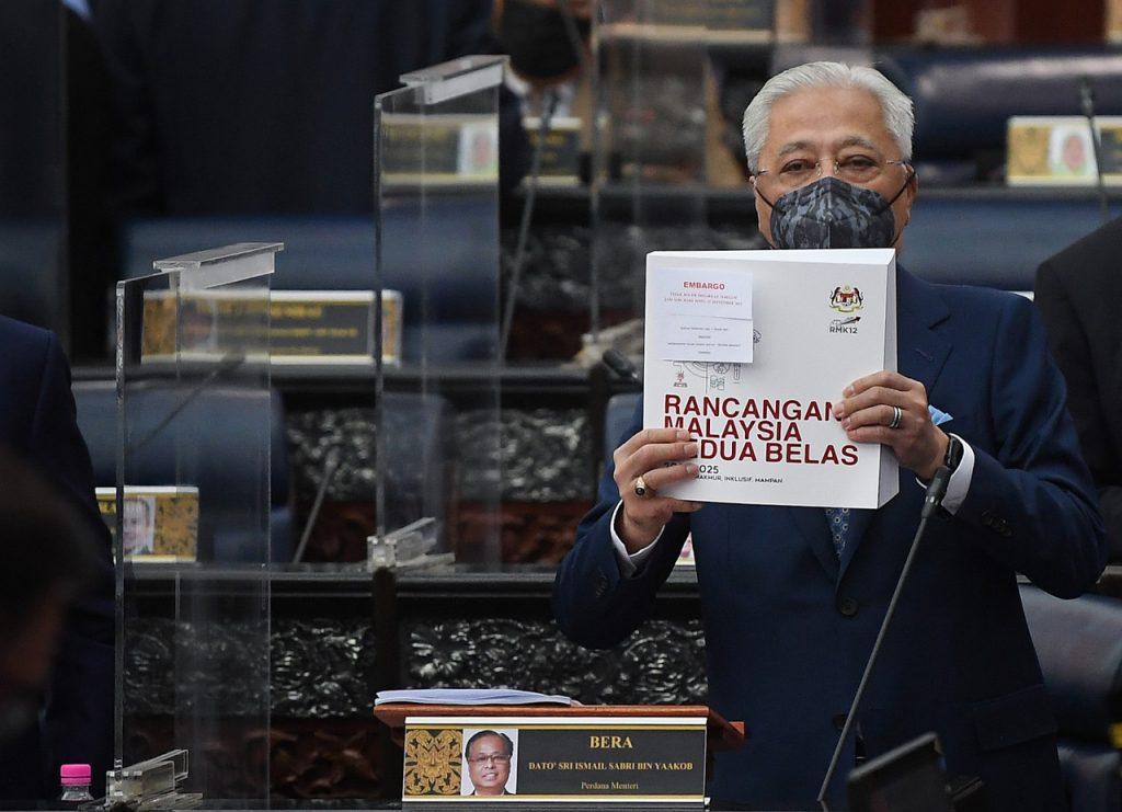 Perdana Menteri Ismail Sabri Yaakob menunjukkan pek dokumen  RMK12 dalam sidang Dewan Rakyat hari ini. Gambar: Bernama