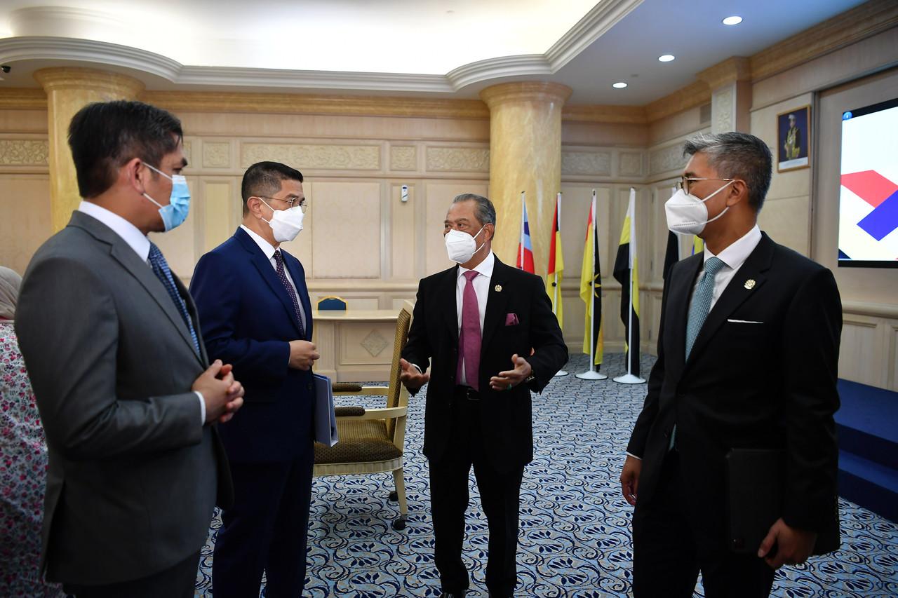 Pengerusi Majlis Pemulihan Negara (MPN) Muhyiddin Yassin (dua, kanan) berbincang dengan Menteri Kanan Perdagangan Antarabangsa dan Industri, Mohamed Azmin Ali (dua, kiri), Menteri Kanan Pendidikan, Radzi Jidin (kiri) dan Menteri Kewangan Tengku Zafrul Tengku Aziz (kanan) selepas mempengerusikan Mesyuarat Majlis Pemulihan Negara di Kementerian Kewangan pada 27 September, 2021. Gambar: Bernama