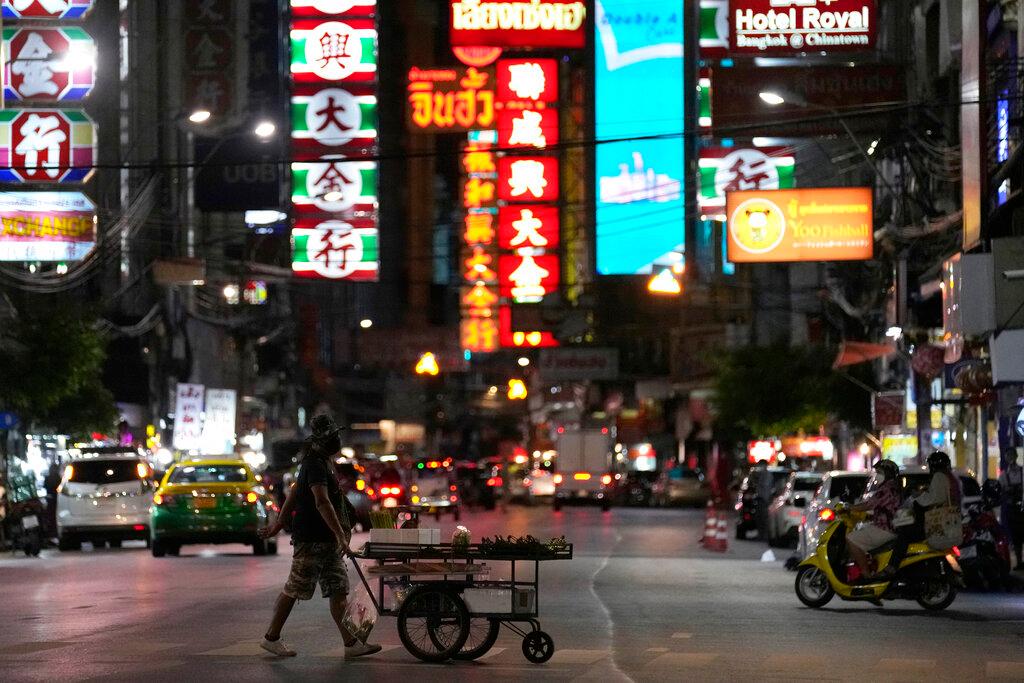 A vegetable vendor pushes his cart across a street in China town in Bangkok, Thailand, on Aug 3. Photo: AP