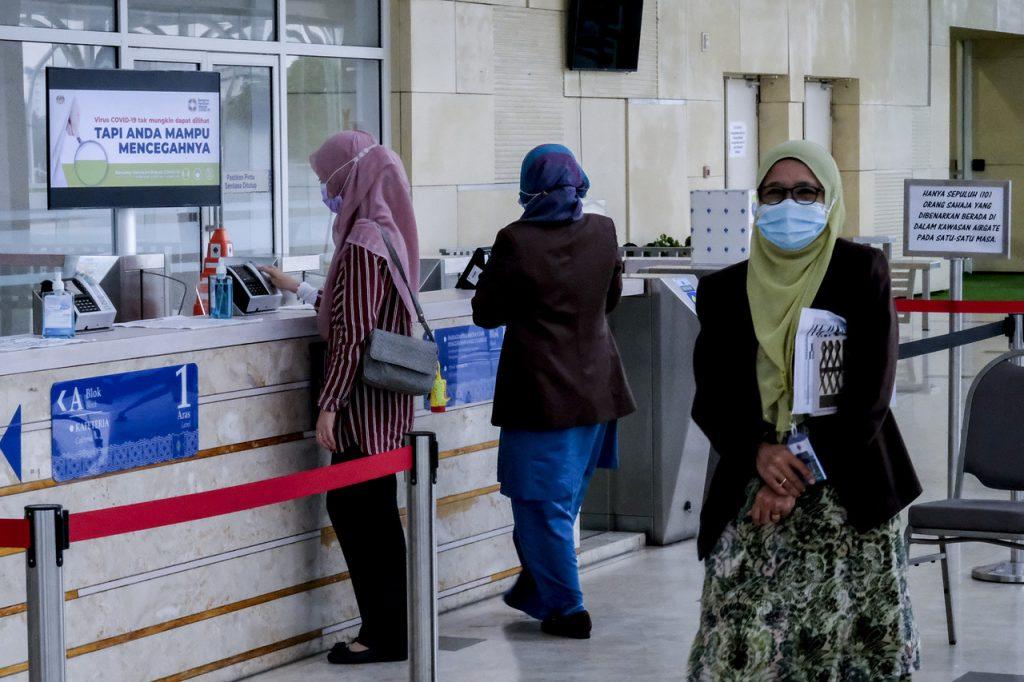 Penjawat awam di Putrajaya mendaftar keluar untuk pulang selepas seharian bekerja di pejabat. Gambar: Bernama