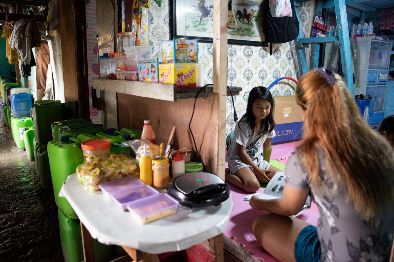 A mother assists her daughter in answering learning materials at their home, as face-to-face classes are yet to resume amid Covid-19, in Manila, Philippines, Sept 16. Photo: Reuters