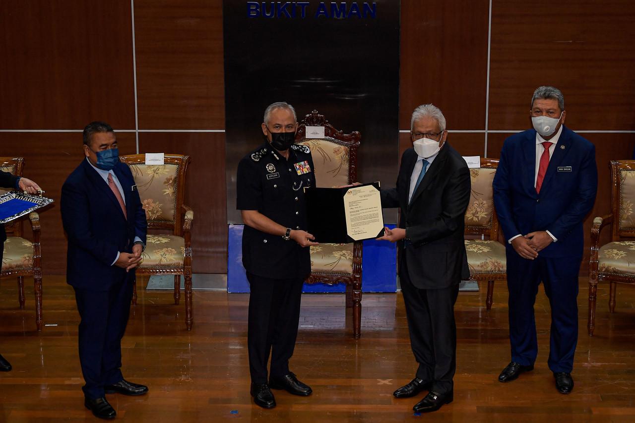 Home Minister Hamzah Zainudin (second right) hands over the letter of appointment to Inspector-General of Police Acryl Sani Abdullah Sani in Bukit Aman, Kuala Lumpur. Photo: Bernama