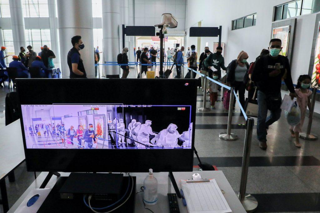 Tourists walk past a thermal scanner at the jetty, as Langkawi reopens to domestic tourists, Sept 16. Photo: Reuters