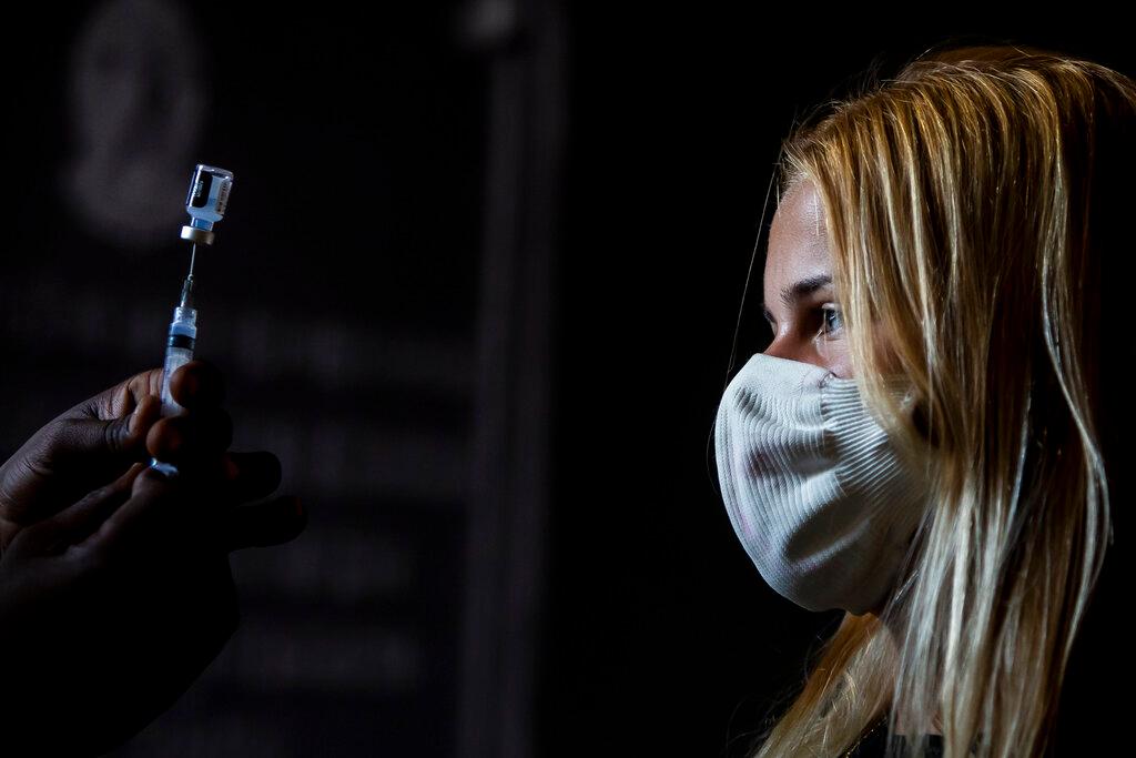 A healthcare worker shows a teenager her dose of the Pfizer Covid-19 vaccine before she is inoculated, on the first day of a vaccination campaign for 17-year-olds, at a vaccination centre in Rio de Janeiro, Brazil, Aug 26. Photo: AP