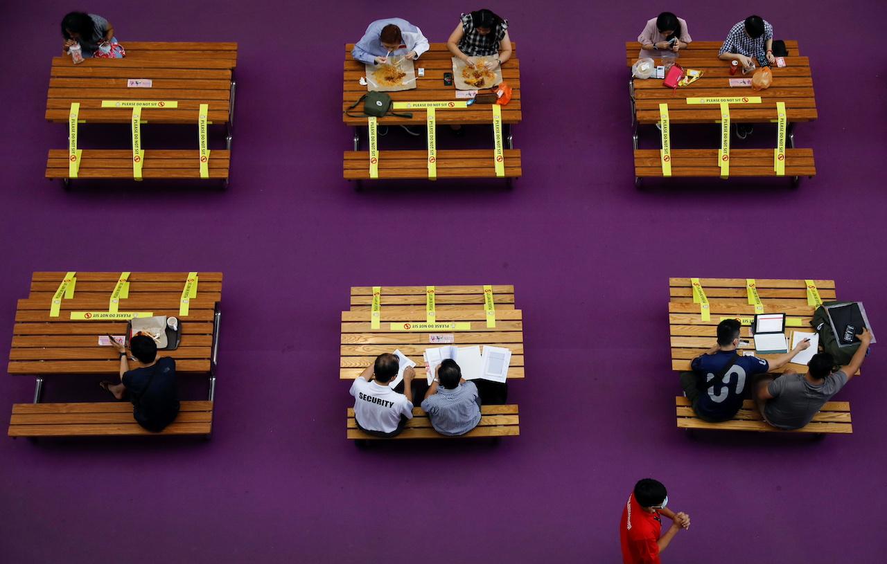 People sit in groups of two at a mall as restrictions on social gathering are tightened due to the surge of Covid-19 cases in Singapore, Sept 29. Photo: Reuters