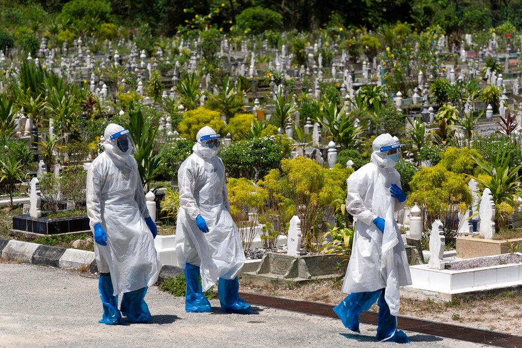 Workers in personal protective equipment leave after burying a Covid-19 victim at a cemetery in Gombak in this Feb 5 file photo. Photo: AP