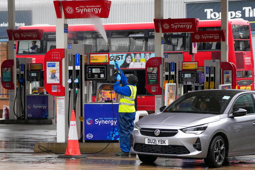 An employee cleans fuel stations at a closed petrol station in London, Sept 30. Photo: AP