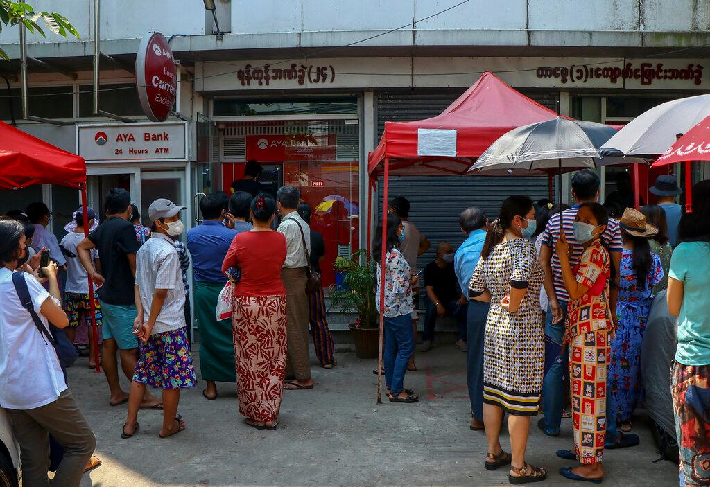 People gather outside ATM machines at a local bank branch in Yangon, Myanmar, in this file photo dated March 17. Online groups, which run mainly on Facebook, have become a way for buyers and sellers of currencies to connect, often relying on trust when arranging physical exchanges of notes. Photo: AP