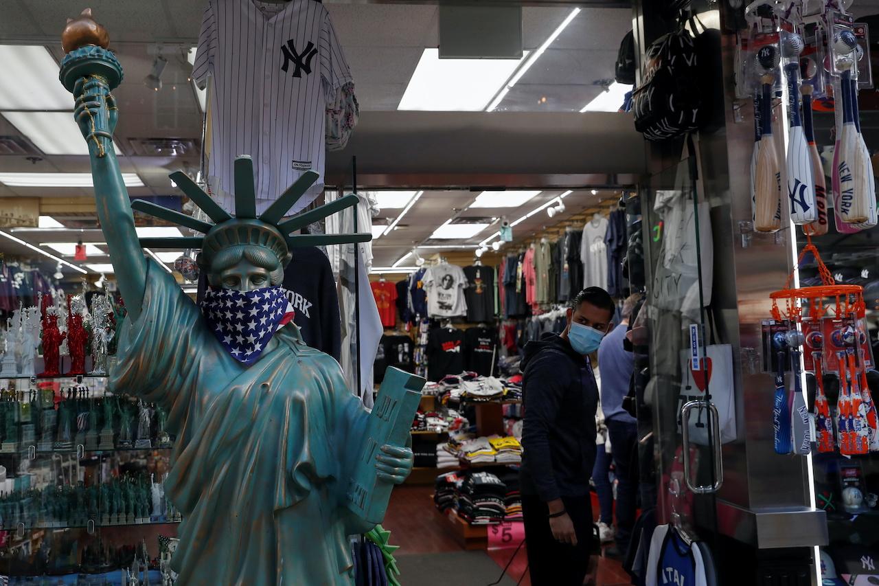 A man wearing a protective face mask looks out a storefront window in the Little Italy section of Manhattan in New York City, US, Oct 1. Photo: Reuters
