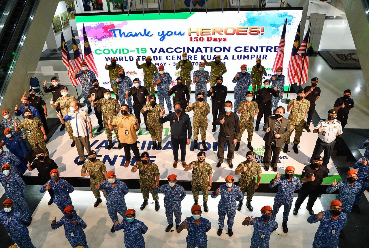 Health Minister Khairy Jamaluddin (centre) shows the peace sign alongside personnel from the World Trade Centre vaccination centre in Kuala Lumpur on its last day of operations yesterday. Photo: Bernama
