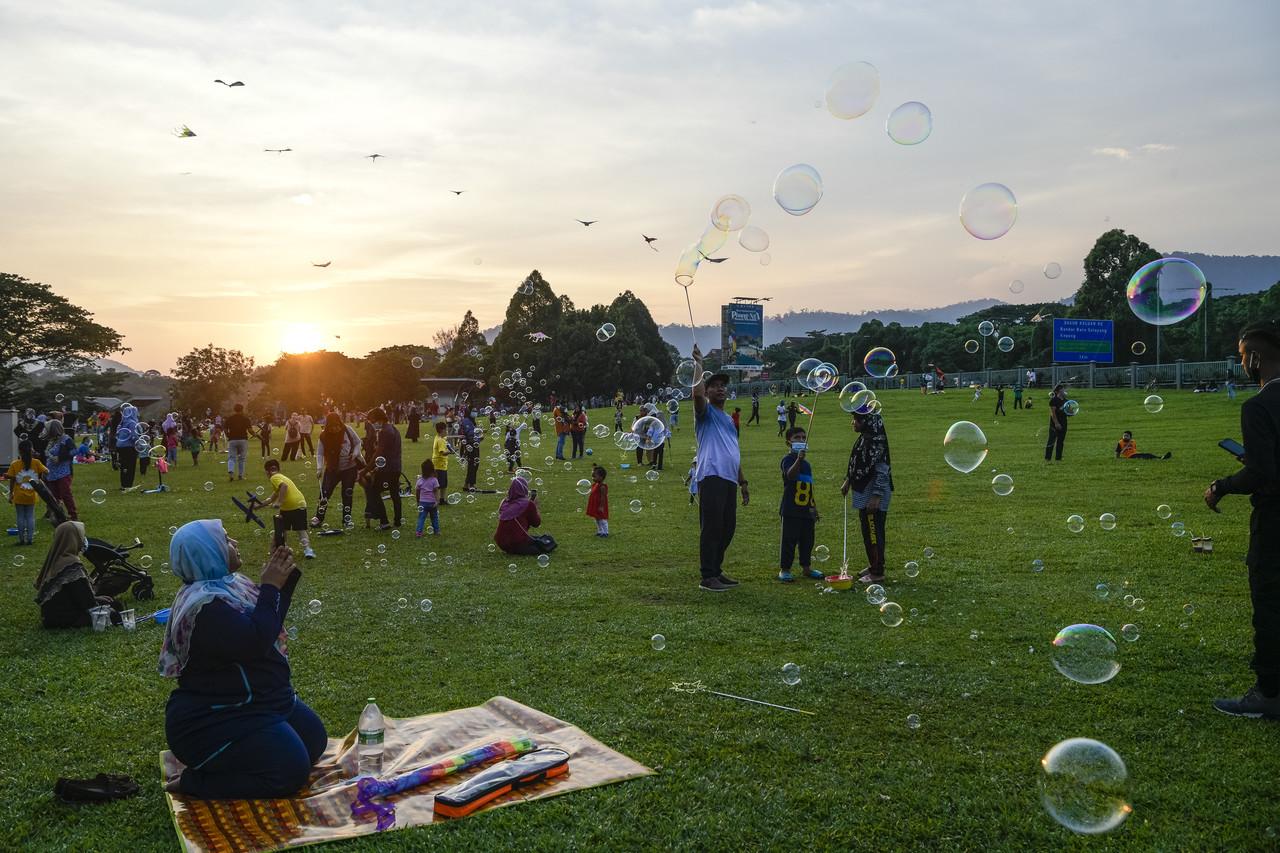 Families enjoy an evening at the park while children play with bubbles at Taman Tasik Metropolitan Kepong in Kuala Lumpur yesterday. Photo: Bernama
