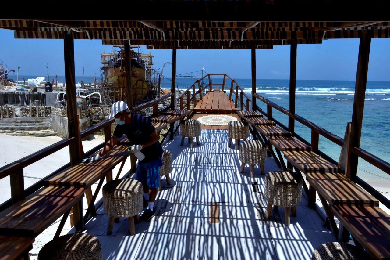 A tourism worker wipes a table as the government eases social restrictions for the resort island in Badung, Bali, Indonesia in this file photo dated Sept 14. Photo: Reuters