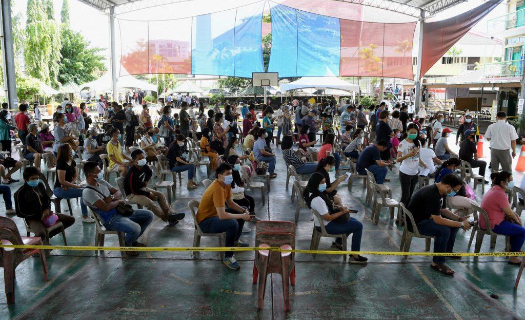 Voters in Kota Kinabalu, Sabah wait to cast their ballots under Covid-19 SOPs in last year's state election. Photo: Bernama