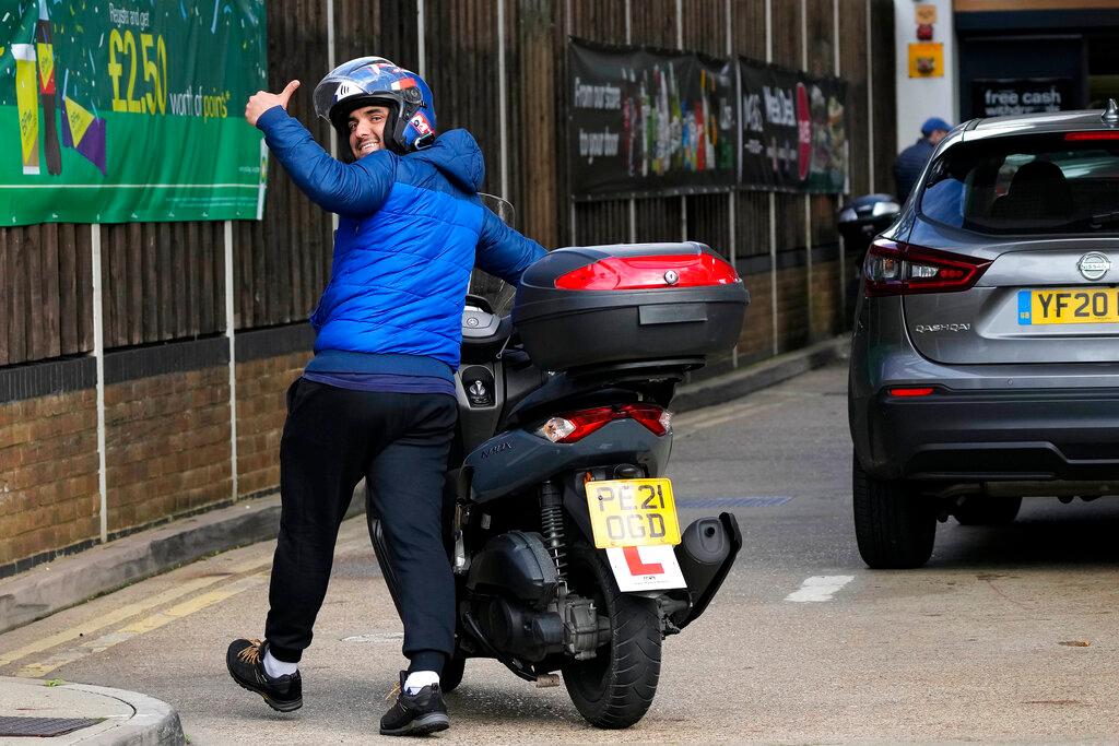 A driver pushes his scooter into a petrol station after running out of fuel in London, Oct 4. Across most of the country, 86% of sites report having both grades of fuel while 3% have only one grade and 11% are dry, the Petrol Retailers Association says. Photo: AP