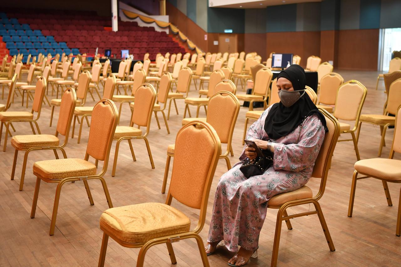 A woman waits to be vaccinated on the last day of operations at the Universiti Sultan Zainal Abidin vaccination centre in Kuala Nerus, Oct 6. Photo: Bernama