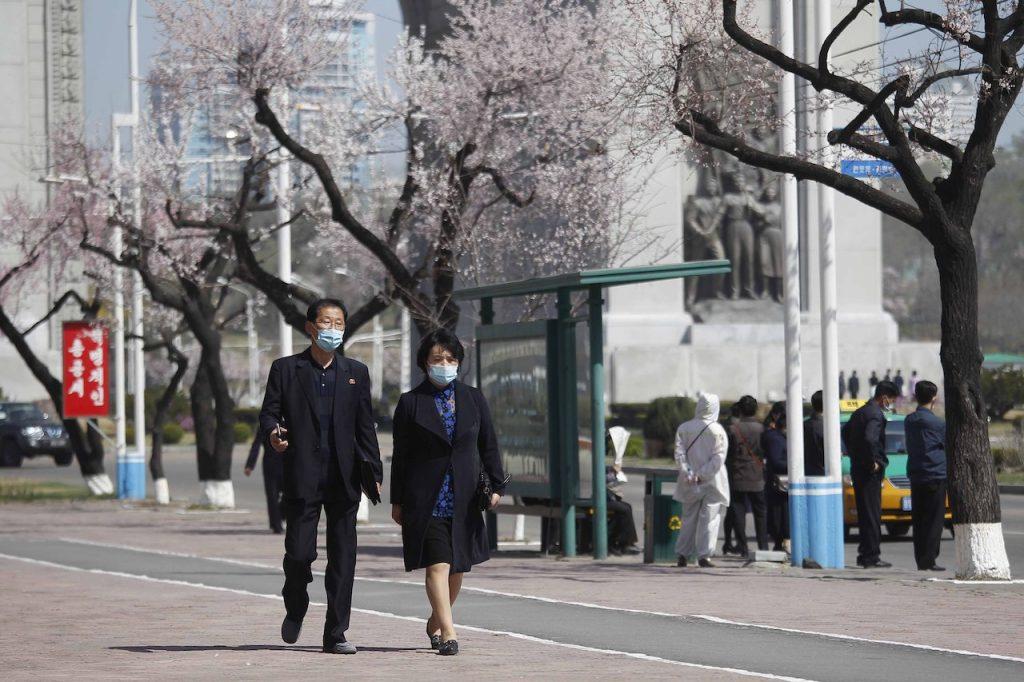 People wearing face masks walk along a street in Pyongyang, in this April 5 file photo. North Korea imposed tough restrictions when the coronavirus pandemic began last year, sealing its borders and other measures in what it saw as a matter of national survival. Photo: AP