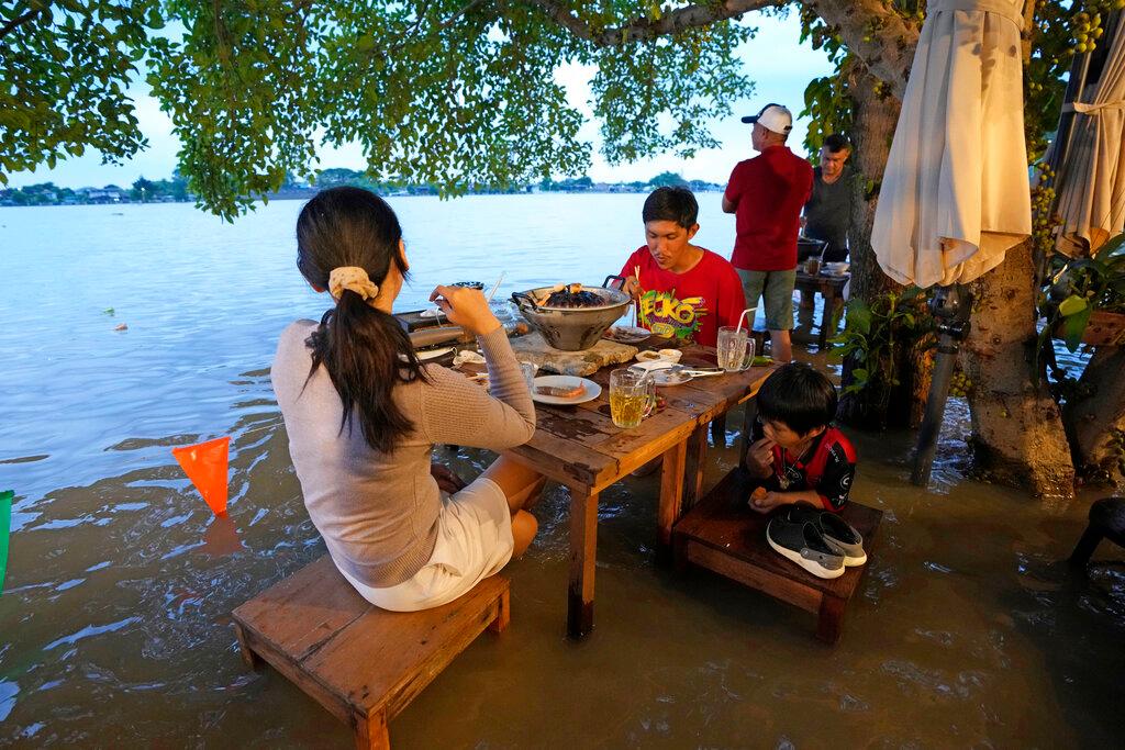 Customers of the riverside Chaopraya Antique Cafe enjoy themselves despite the extraordinary high water levels in the Chao Phraya River in Nonthaburi, near Bangkok, Thailand, Oct 7. Photo: AP