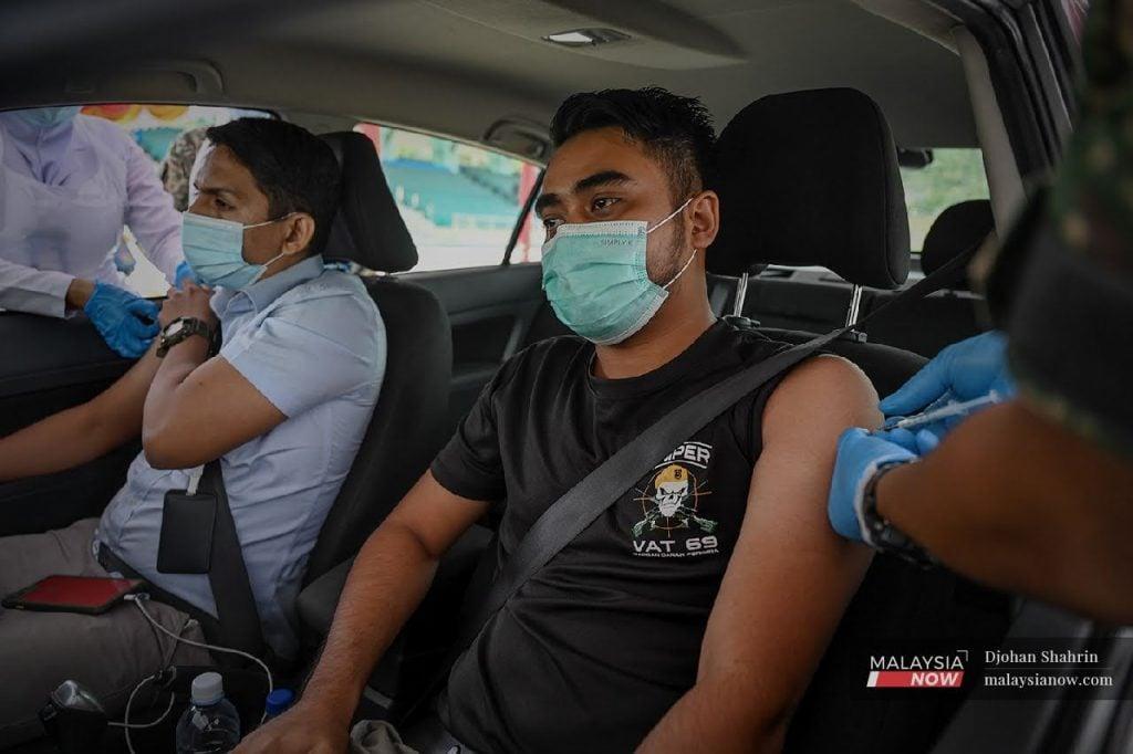 Petugas perubatan tentera memberi vaksin kepada anggota tentera dan penduduk di Kem Sungai Besi secara pandu lalu.