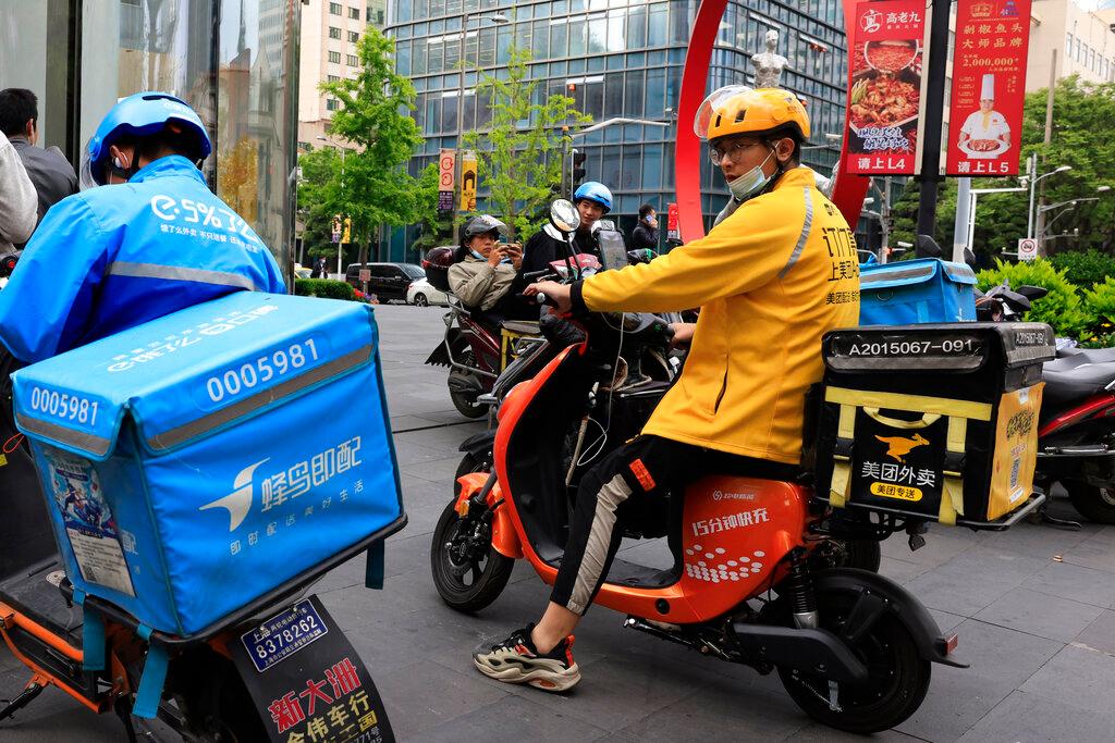 In this April 21 file photo, a Meituan delivery man in yellow goes on his rounds in Shanghai.  Photo: AP