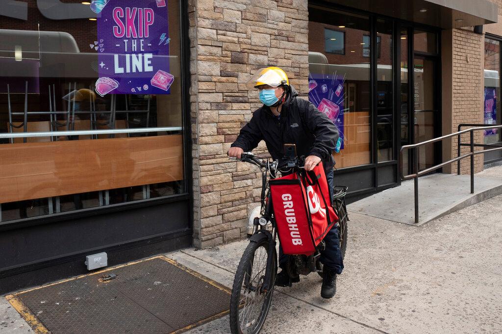 In this April 21 file photo, a delivery man cycles with a food bag from Grubhub in New York. Photo: AP