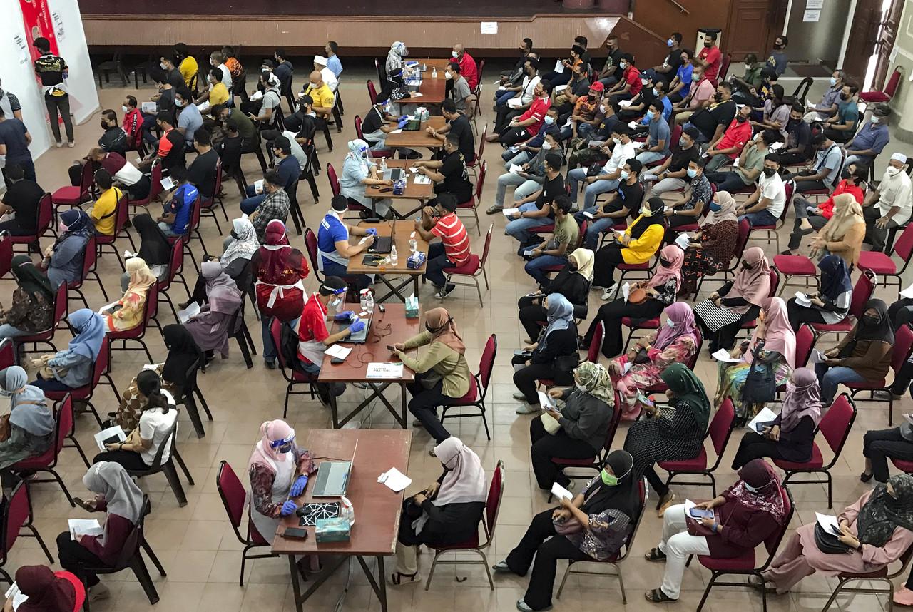 People wait for their turn to be vaccinated against Covid-19 at the Dewan Perniagaan Cina Kelantan vaccination centre in Kota Bharu. Photo: Bernama