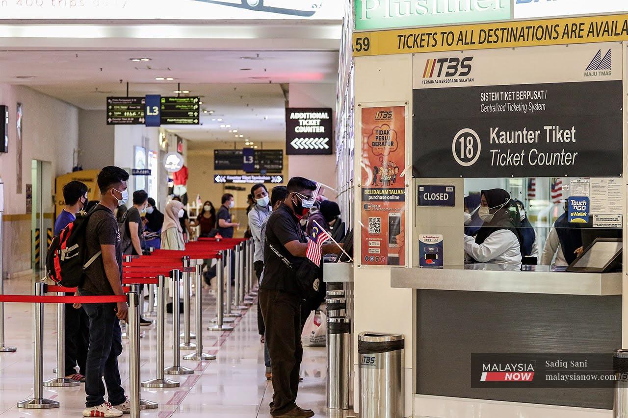 Travellers queue at the ticket booth at the Southern Integrated Terminal in Kuala Lumpur as interstate travel resumes after months of restrictions.