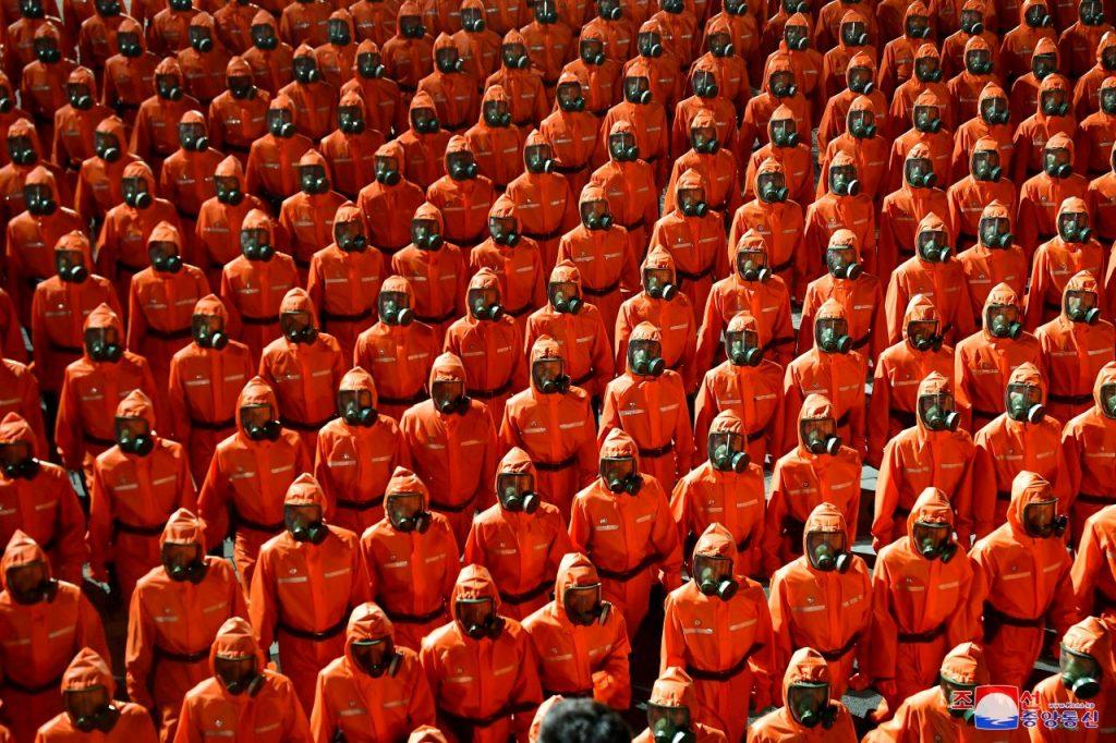Personnel in orange hazmat suits march during a paramilitary parade on Sept 9. North Korean leader Kim Jong Un says Pyongyang is seeking to prevent war. Photo: Reuters
