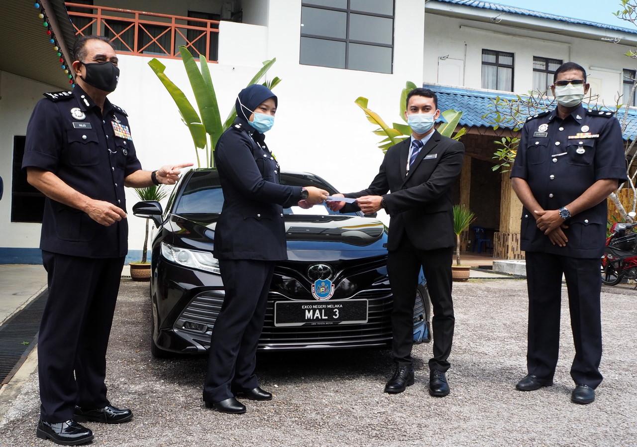 Melaka police chief Abdul Majid Mohd Ali (left) and other officials with the black Toyota Camry seized from a condominium parking lot in Jalan Perak, Bachang. Photo: Bernama