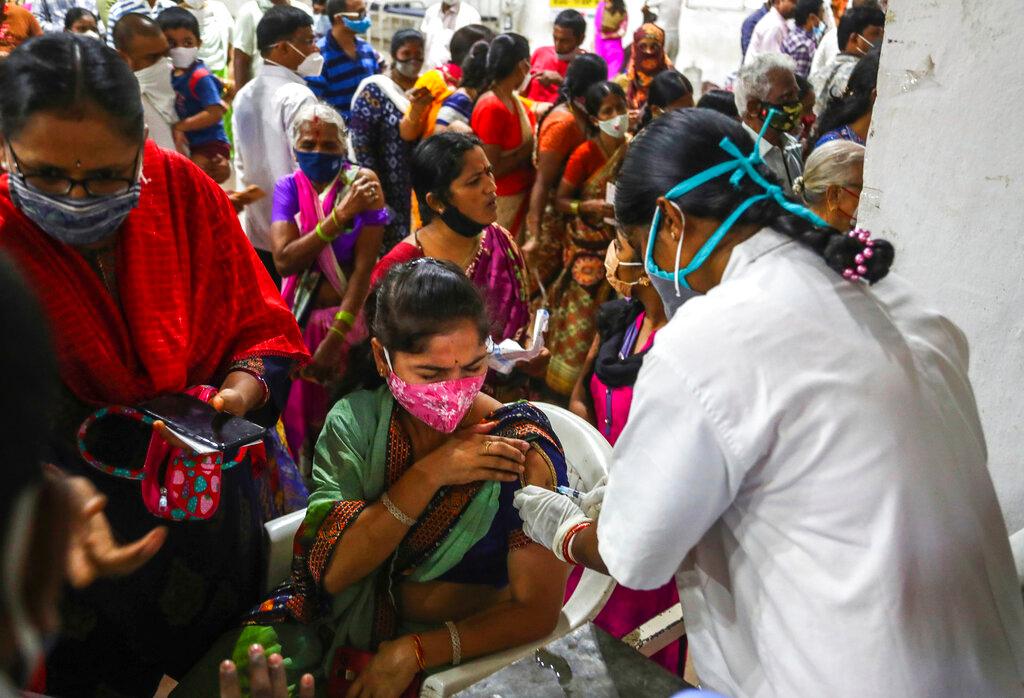 A health worker administers a dose of Covid-19 vaccine as hundreds line up to receive their second shots at the municipal stadium in Hyderabad, India, July 29. Photo: AP
