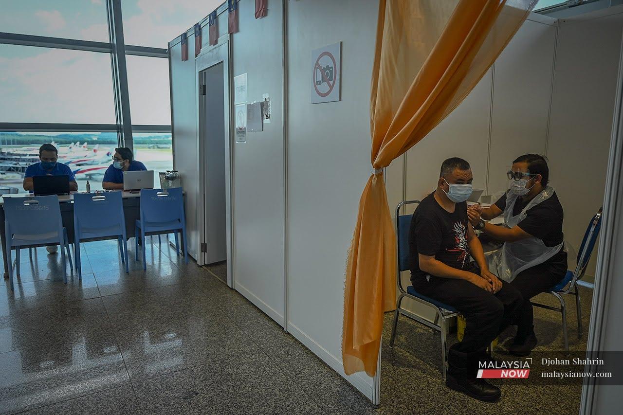 Petugas kesihatan menjalankan vaksinasi kepada pekerja-pekerja Lapangan Terbang Antarabangsa Kuala Lumpur bagi dos kedua kategori industri di Sepang.