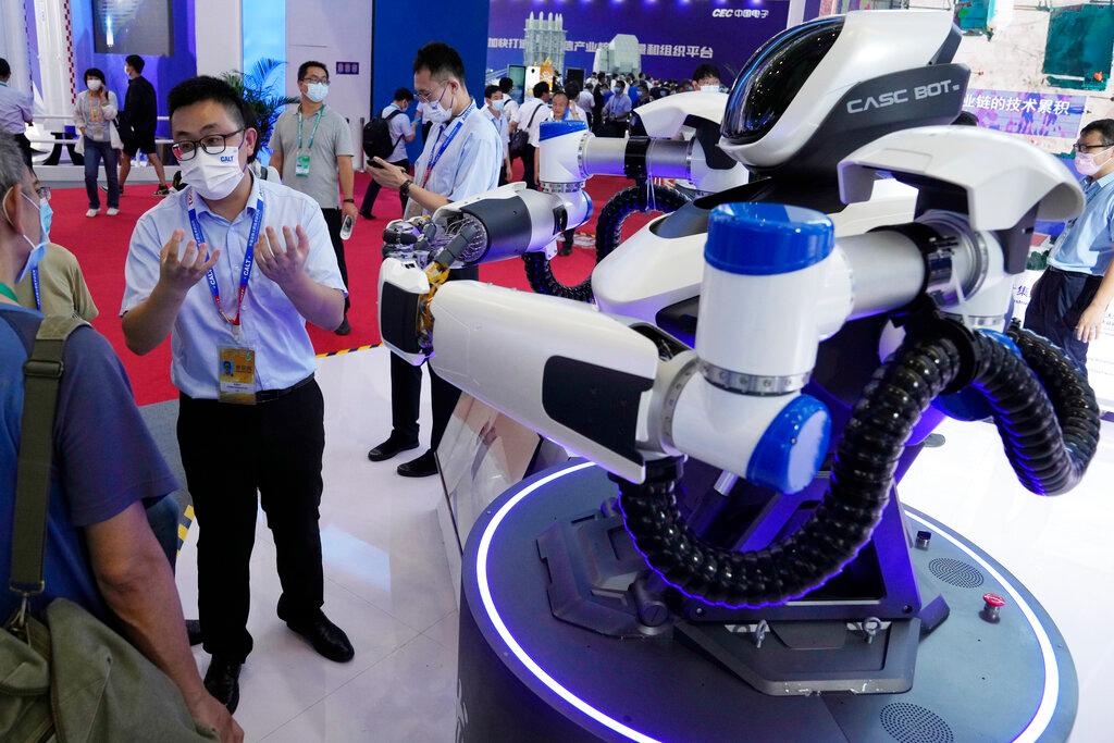 Wakil jualan robot yang dibina di China Aerospace Science and Technology Corporation atau CASC menerangkan kepada pelawat pameran Airshow China 2021 mengenai Casc Bot keluaran syarikat itu. Gambar: AP