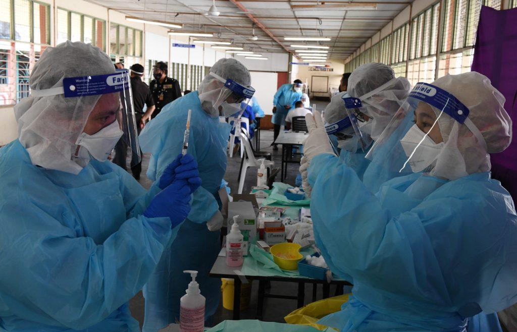 Petugas kesihatan mempersiapkan dos vaksin di penjara Pulau Pinang. Vaksinasi dijalankan ke seluruh pelusuk negara sejak PICK dimulakan. Gambar: Bernama