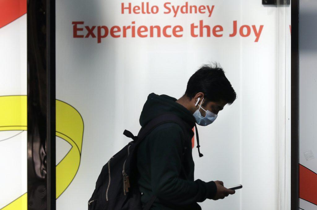 A man wears a mask as he walks in Sydney, July 7. Australia closed its borders in March 2020 in response to the pandemic, allowing entry almost exclusively to only citizens and permanent residents who were required to undergo a mandatory two-week hotel quarantine at their own expense. Photo: AP