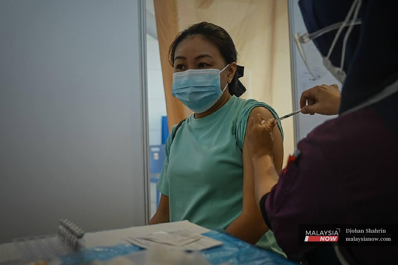 Petugas kesihatan menjalankan vaksinasi kepada pekerja-pekerja Lapangan Terbang Antarabangsa Kuala Lumpur bagi dos kedua di Sepang.