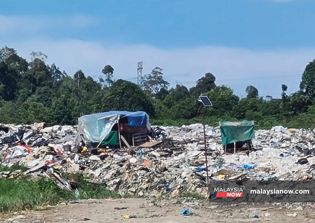 A tiny shack stands amid piles of garbage at a dump site in Bintulu, Sarawak.