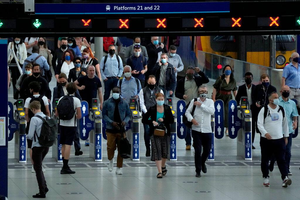 People wear face masks to curb the spread of coronavirus during the morning rush hour at Waterloo train station in London, July 14. Photo: AP