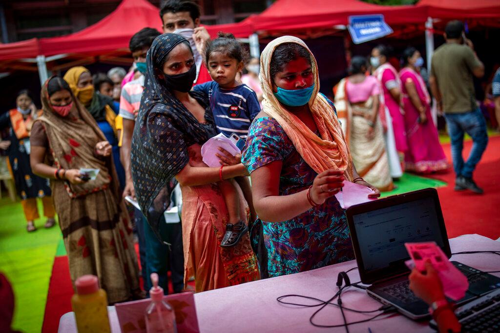 People wait to register themselves to receive vaccine for Covid-19 during an inoculation drive in New Delhi, India, Sept 29. Photo: AP