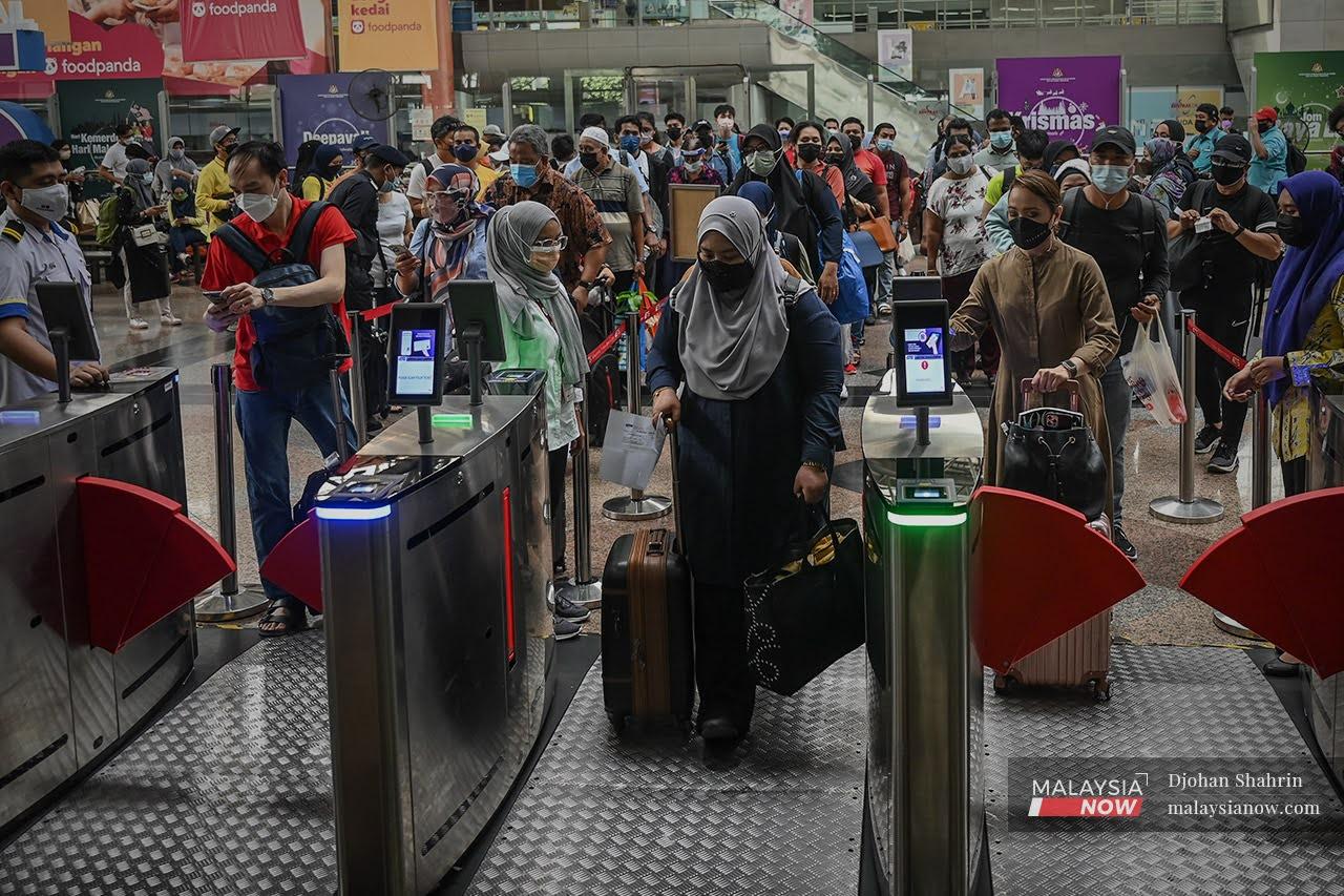 Travellers wait for their train to arrive at the KL Sentral KTM station after the government's green light for those who have been fully vaccinated to cross state lines.