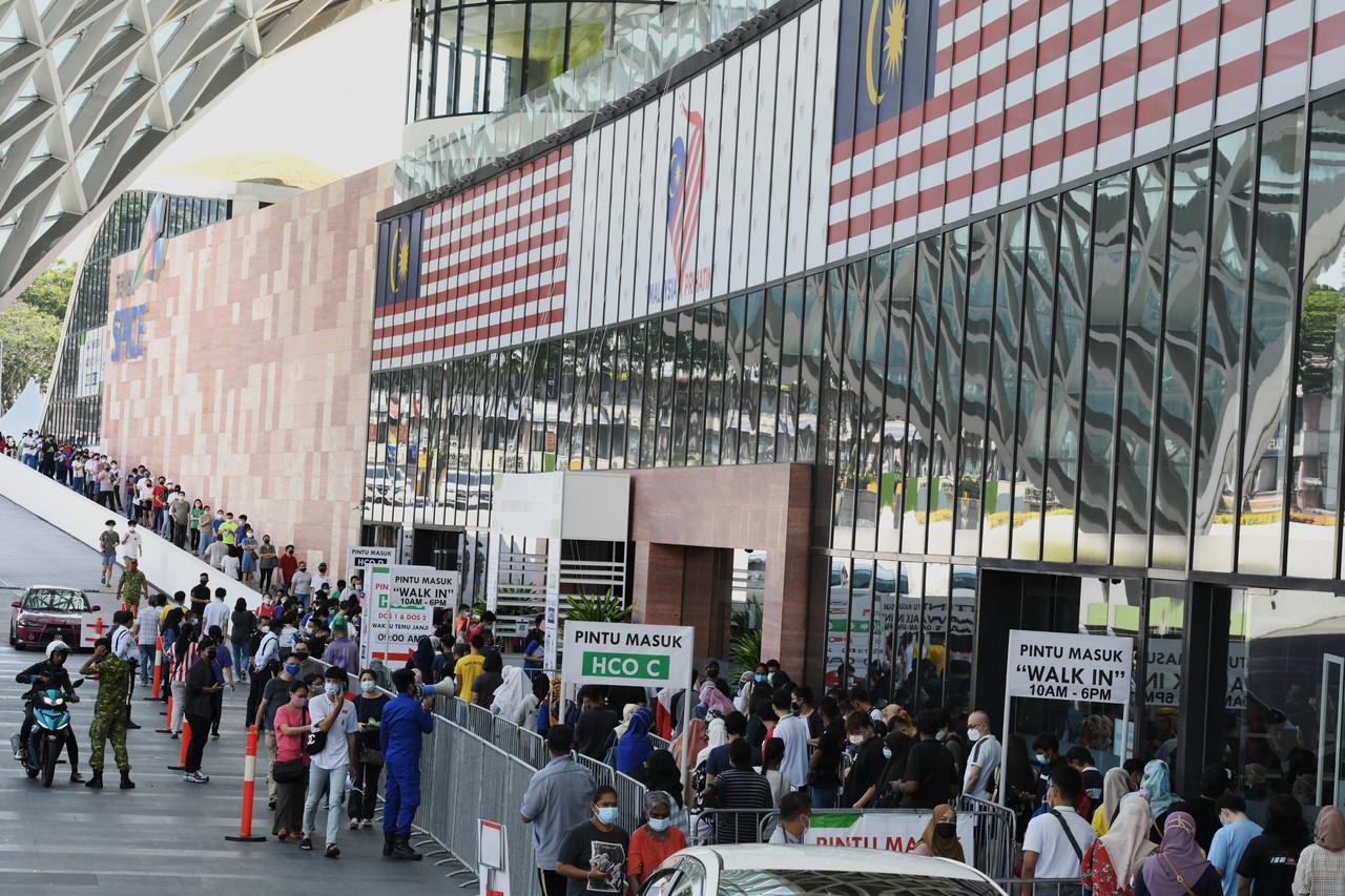 Teenagers queue with their parents and guardians outside the vaccination centre at the Spice Convention Centre in Bayan Baru, Penang, on Sept 23.