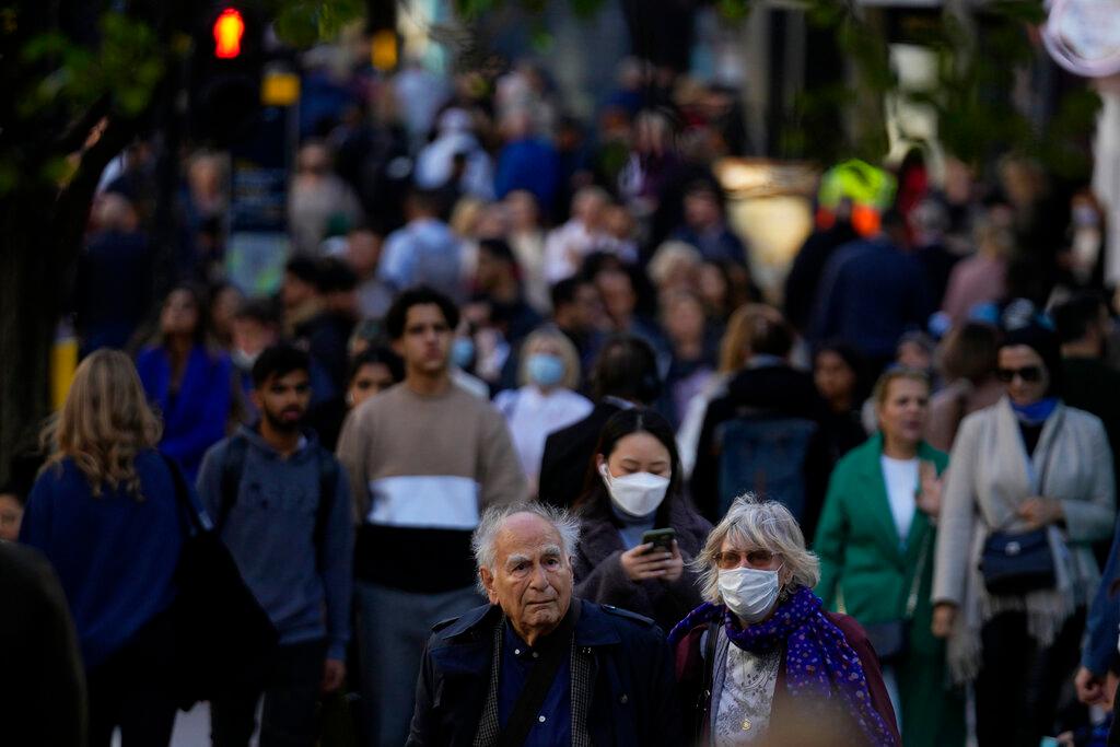 People, some wearing face masks. walk along the Oxford Street shopping area of central London, Oct 20. Britain is currently battling the second-highest infection rate in the world, behind the US, with more than 50,000 cases recorded on Thursday – the highest since July. Photo: AP