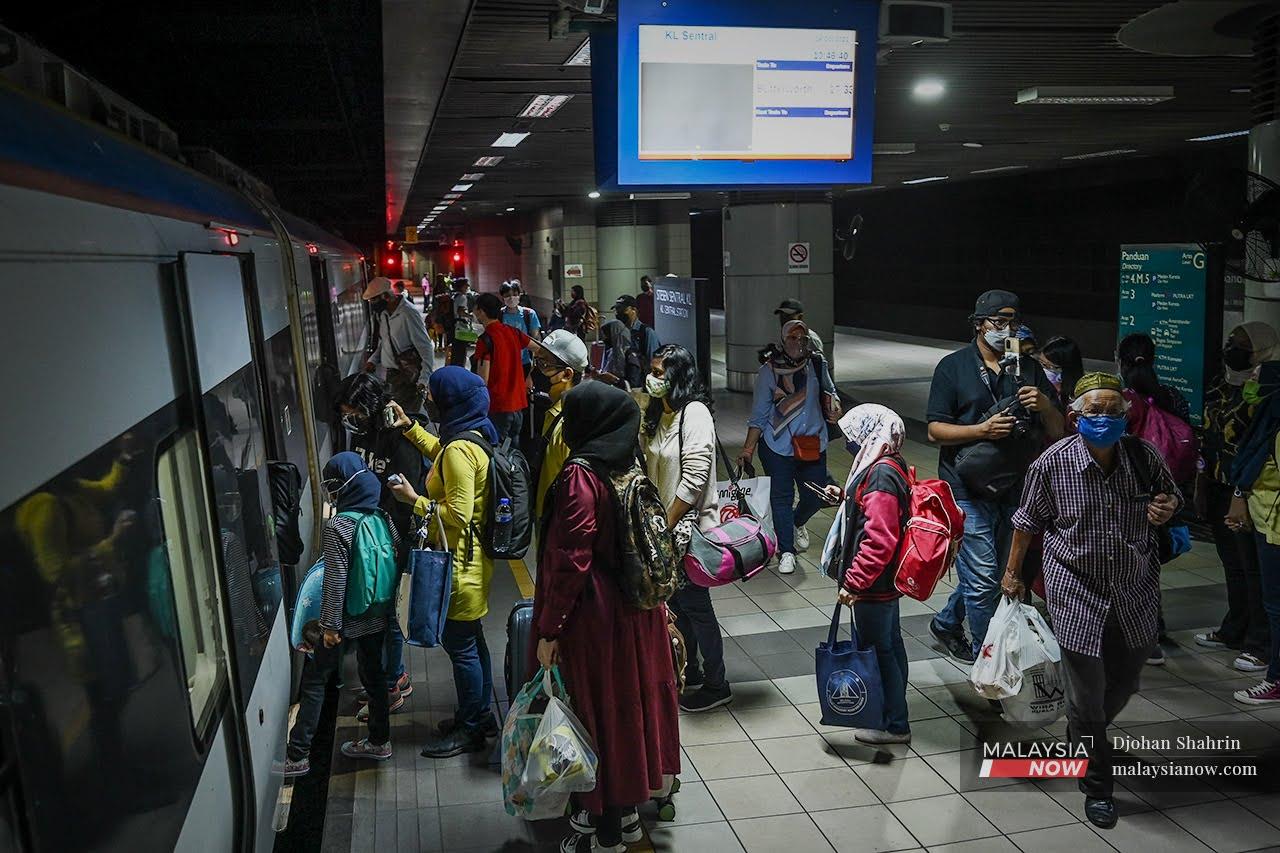 Commuters wait for a train at KTM's KL Sentral station after the government's green light for interstate travel for the fully vaccinated.