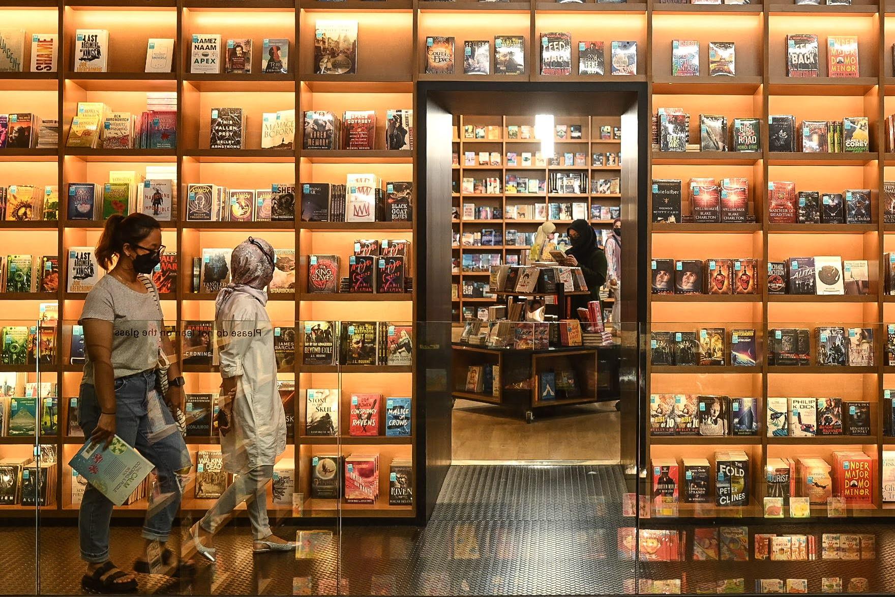 Dua  pengunjung melalui rak buku di Kedai Buku Excess, Nusajaya Johor. Di bawah Pelan Pemulihan Negara kebanyakan sektor kini mulai menjalankan operasi termasuk kedai buku di seluruh negara.