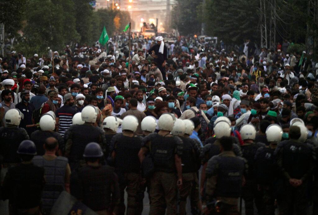 Police officers block the way of the supporters of Tehreek-e-Labiak Pakistan, a radical Islamist political party, marching toward Islamabad, in Lahore, Pakistan, Oct 22. Photo: AP