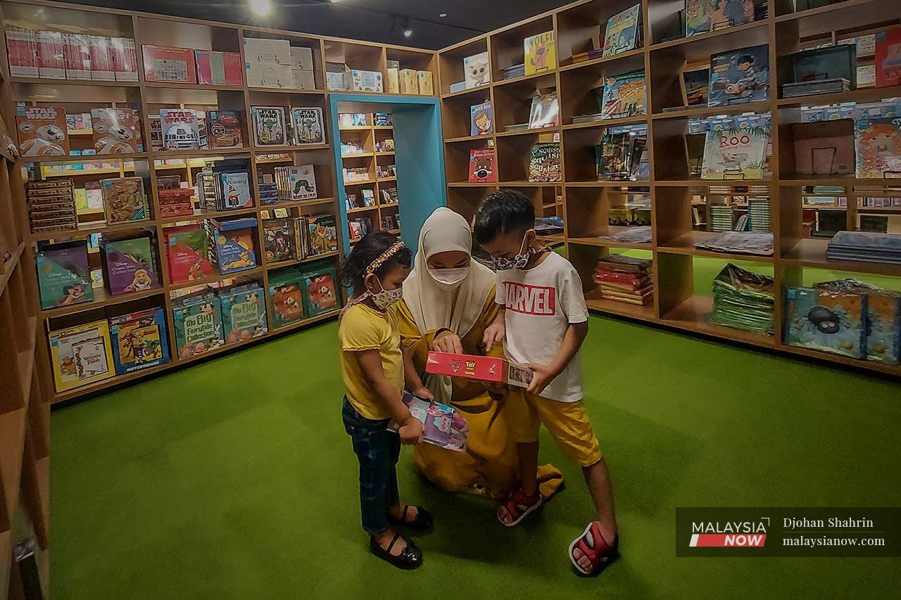Seorang ibu memilih buku kepada anak-anaknya di Kedai Buku Excess, Nusajaya Johor. Kelonggaran di bawah Pelan Pemulihan Negara memberikan kelebihan kepada mereka yang menerima vaksinasi lengkap.