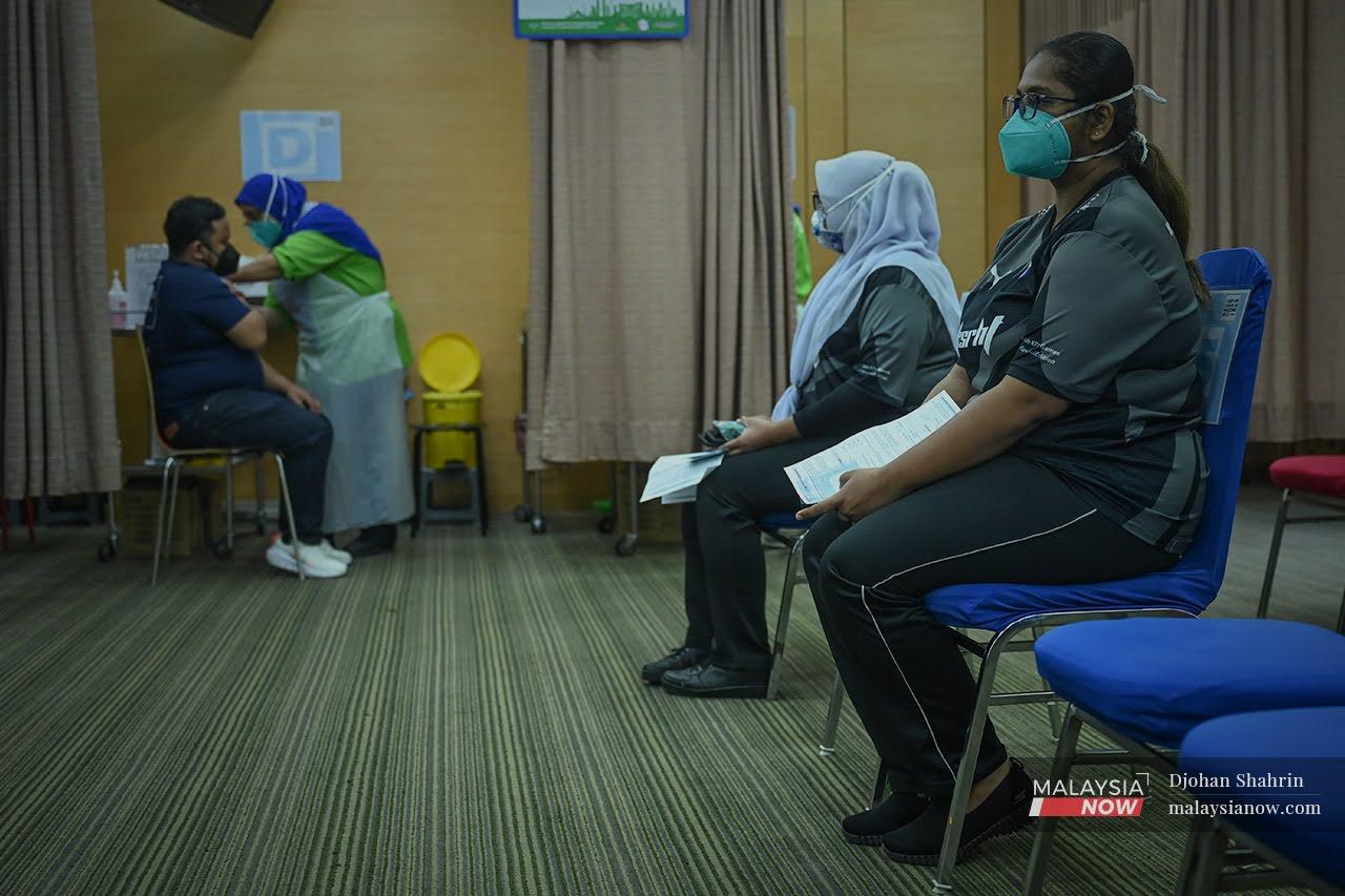 Health workers wait to receive their booster shots of Covid-19 vaccine at KPJ Tawakkal in Jalan Pahang, Kuala Lumpur.