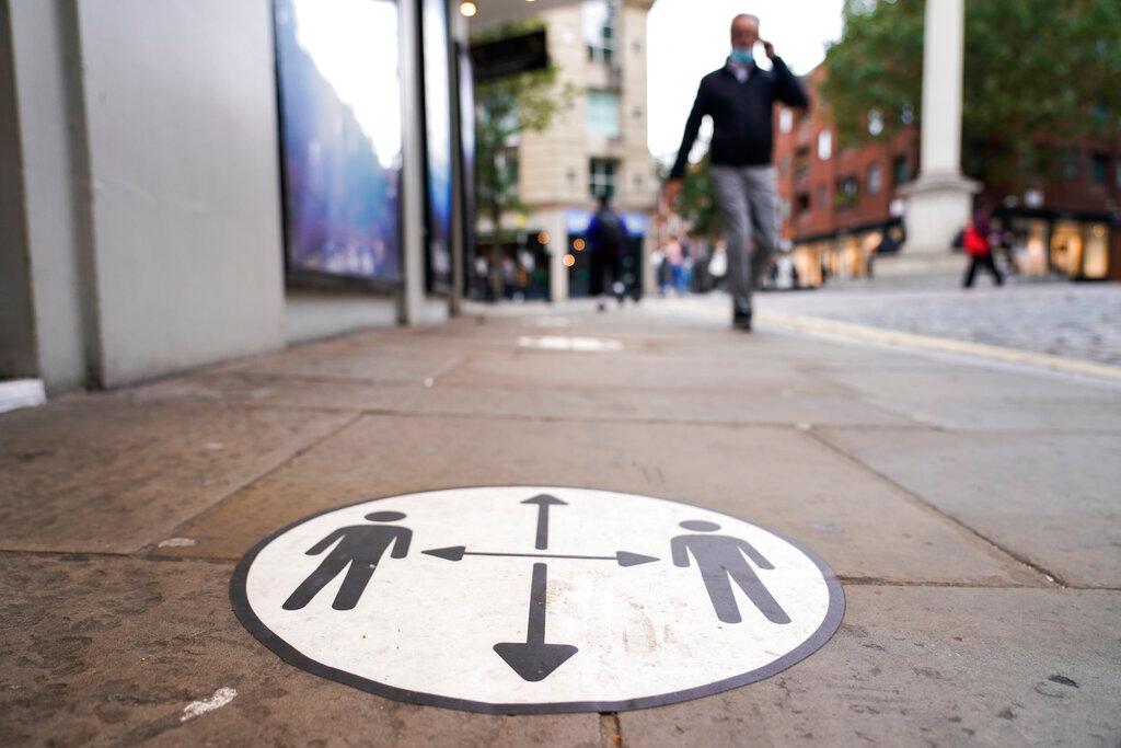 A man walks past a social distancing sign in the area of Covent Garden, in London, Oct 19. The majority of detected Covid-19 cases involving the AY.4.2 Delta subvariant have been in Britain. Photo: AP