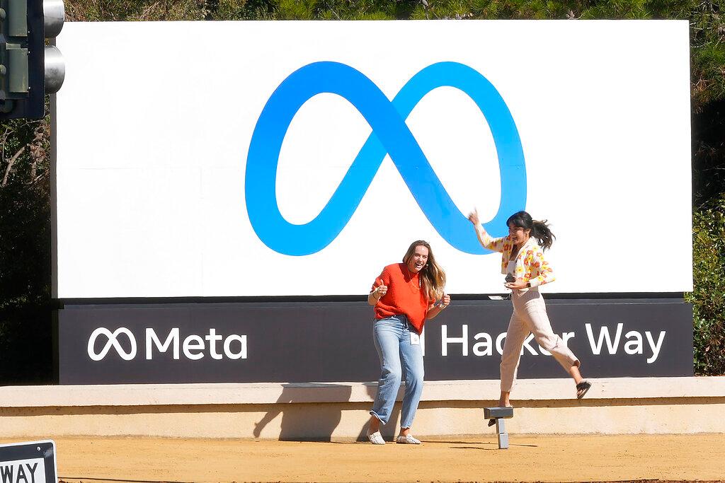 Facebook employees take a photo with the company's new name and logo outside its headquarters in Menlo Park, California, Oct 28, after the company announced that it is changing its name to Meta Platforms Inc. Photo: AP